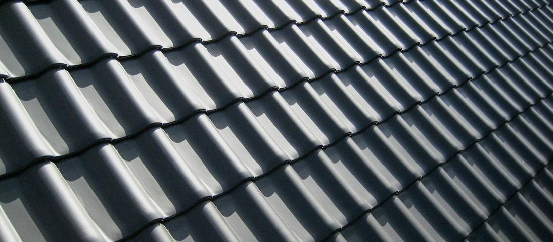 A pattern of roof tiles in sharp afternoon light